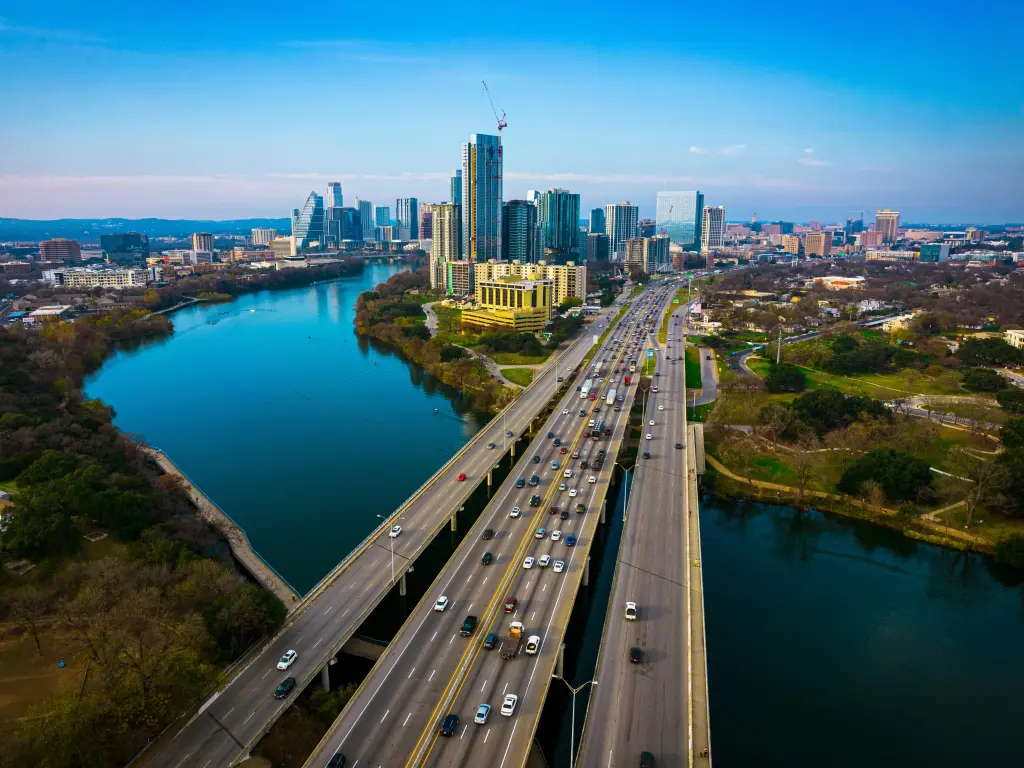 Interstate road crossing the river and going into the city with the city's skyline in the background