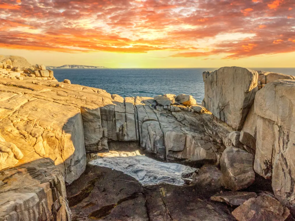 Sun setting over the Natural Bridge with the ocean in the background