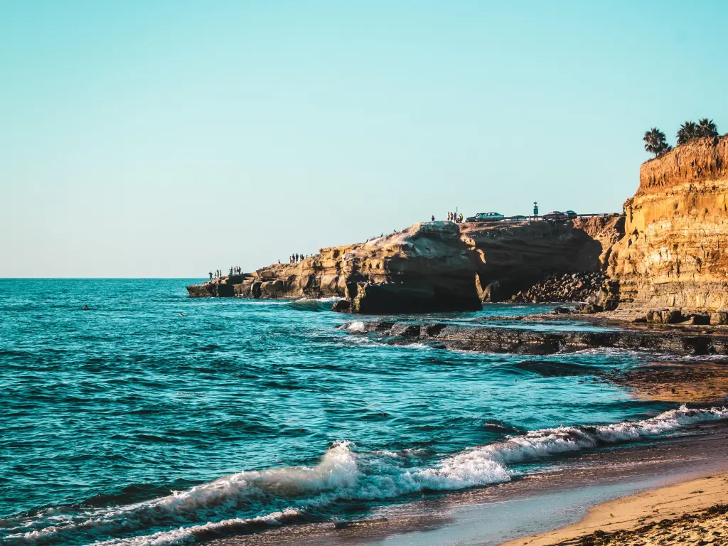 Dramatic waves at the beach with sand-colored cliffs in the background