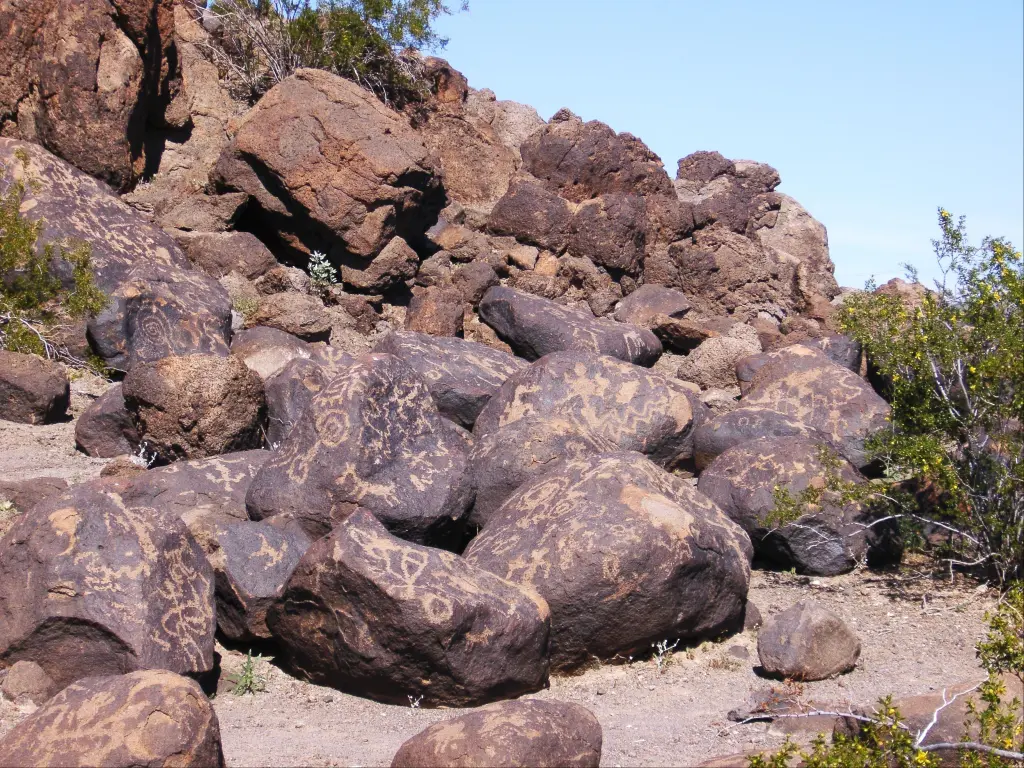 Petroglyphs on round rocks piled together in the desert