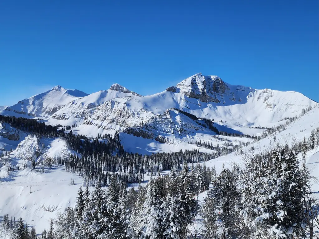 View of snowy mountain side at Jackson hole ski resort on a clear day, in the Teton National Forest