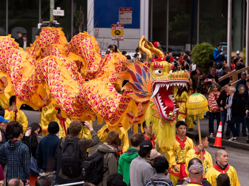 Golden Chinese dragon being carried by participants of the parade during Chinese New Year celebrations