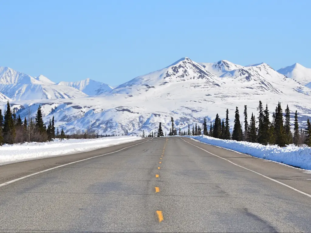 Scenic Highway in Alaska, a mountain is in the background with blue skies