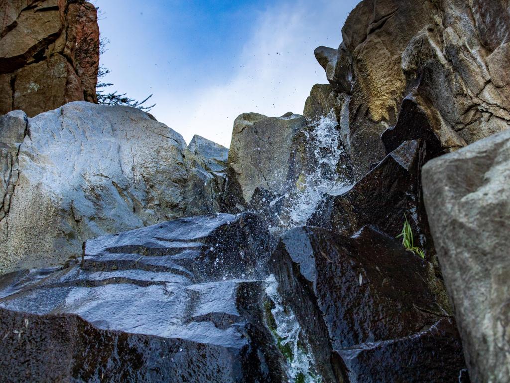 Ortega Falls, California, USA with water falling over boulder rocks on a sunny day.