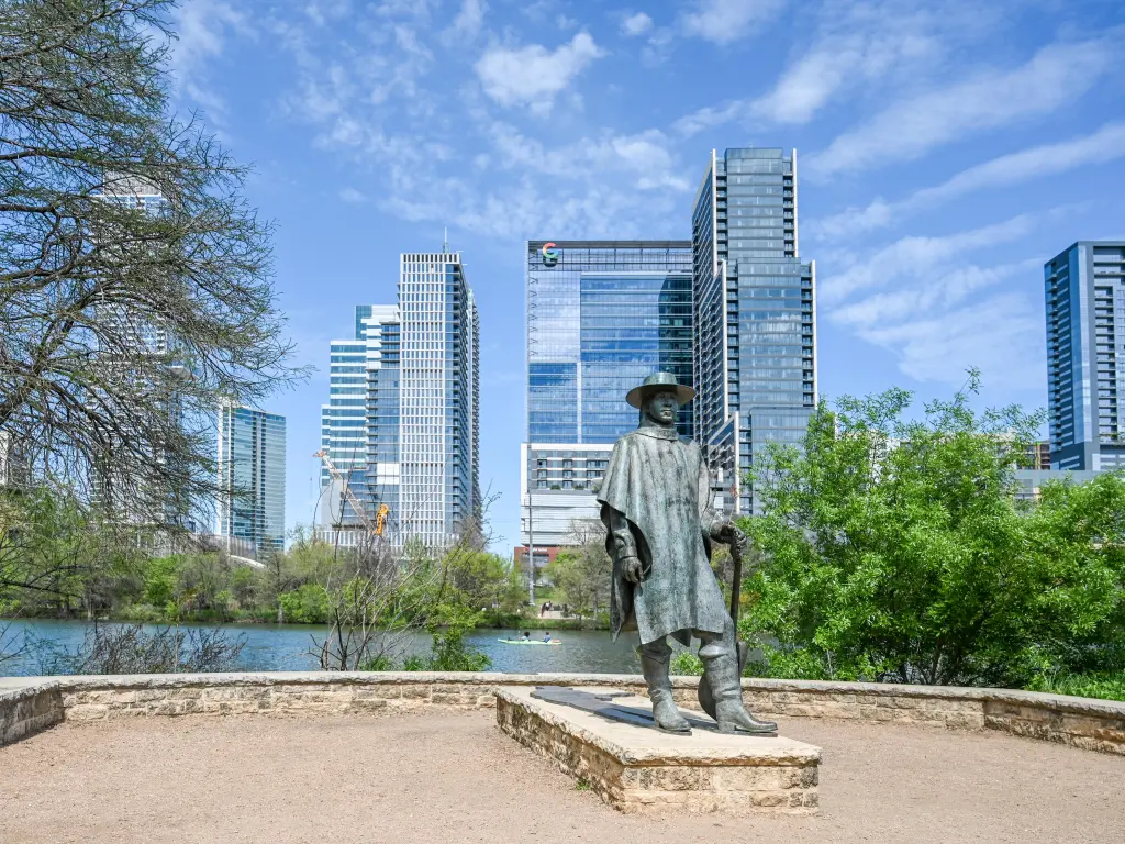 Sculpture of Stevie Ray Vaughan with the river and city's skyscrapers in the background