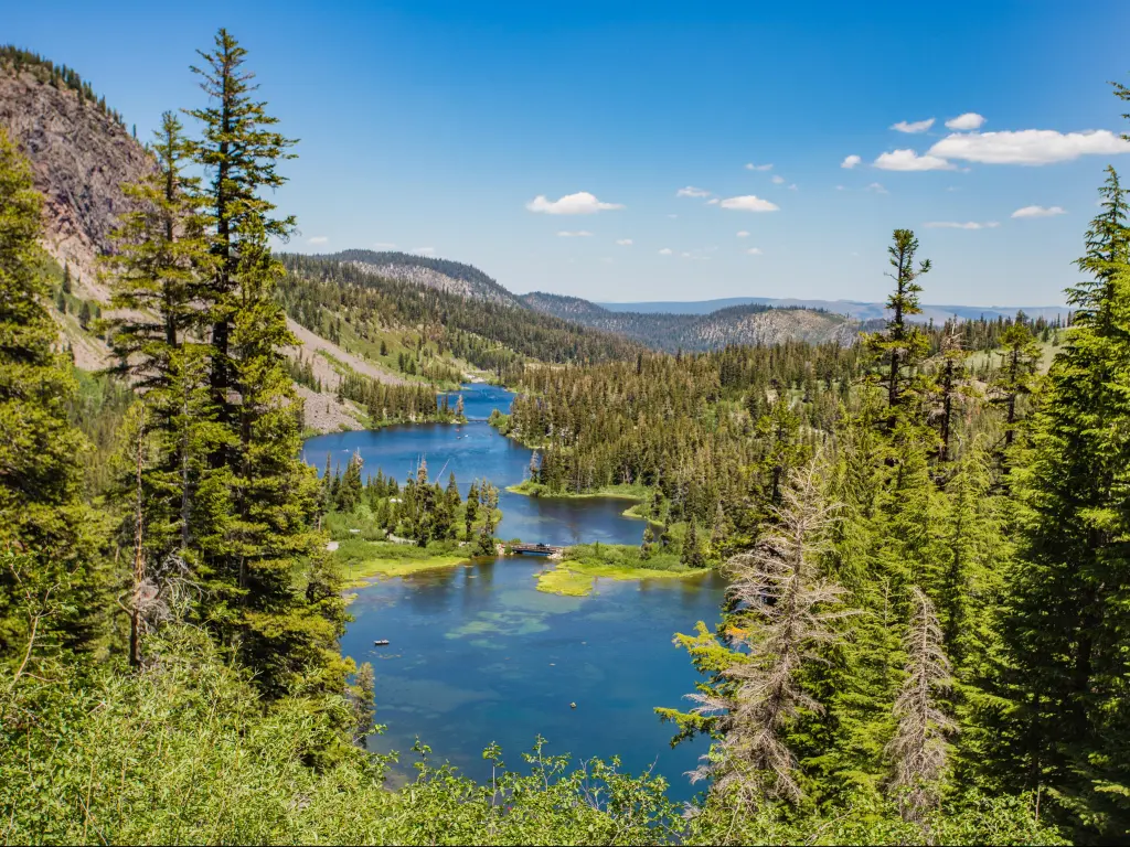 View of Mammoth Lakes with pine trees and vivid blue lake nestled between the mountains