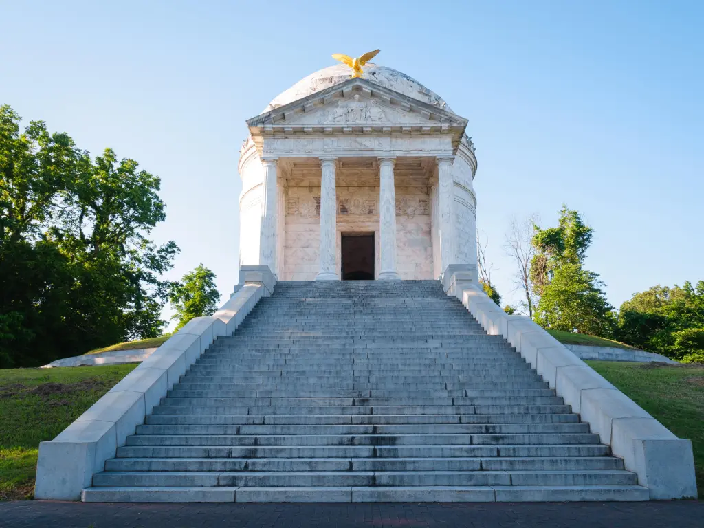 White monument in the park with stairs leading up to it