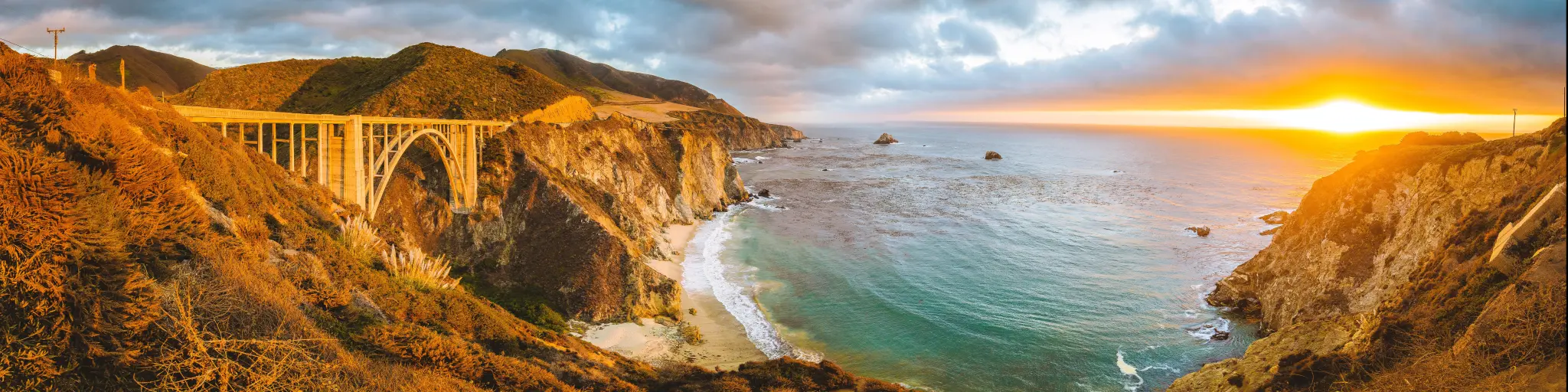 Panoramic view of the Bixby Creek Bridge on the Pacific Coast Highway in California at sunset with beautiful golden light