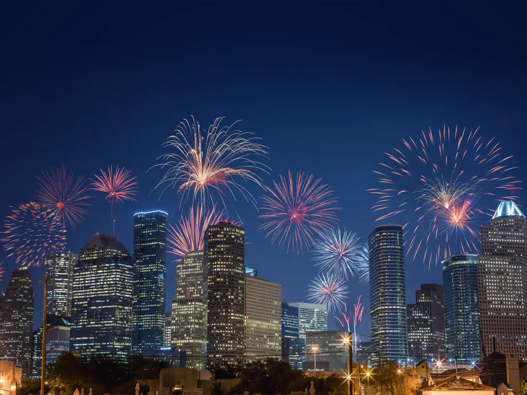 The city skyline with colorful fireworks with lit-up skyscrapers in the foreground