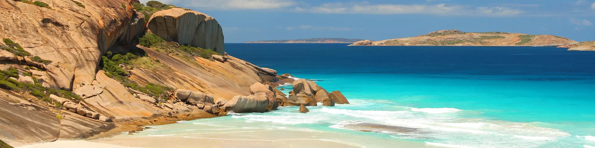 Beautiful white sand beach with blue ocean and blue sky in the background