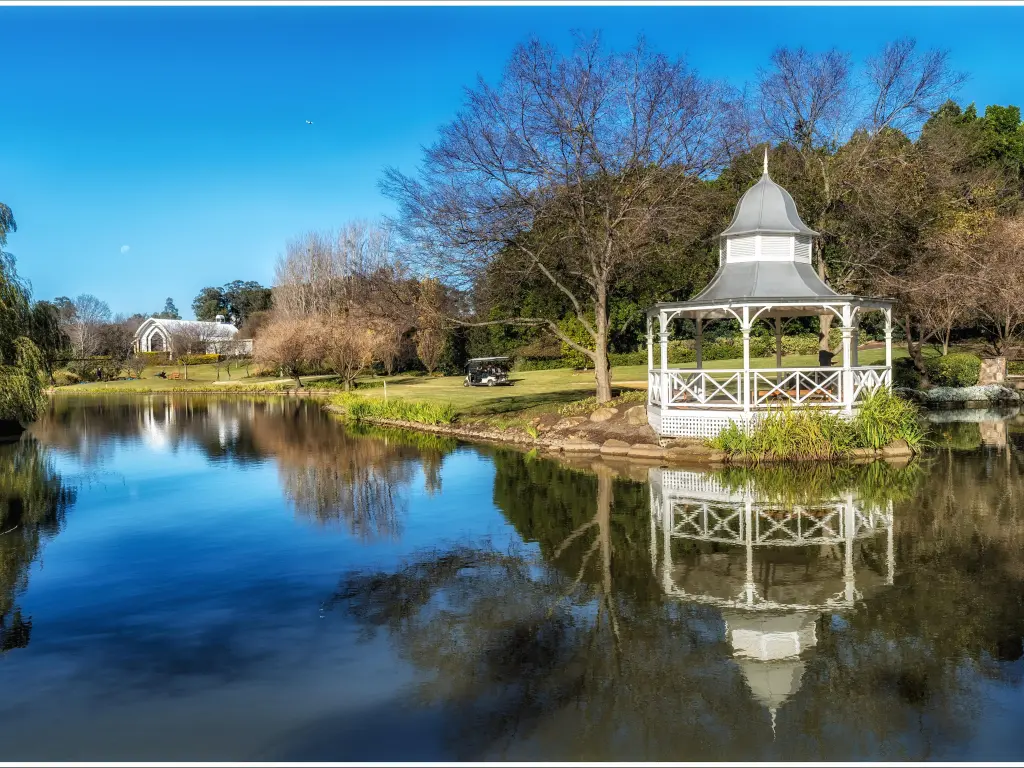 Beautiful gazebo next to a pond in the gardens on a sunny day