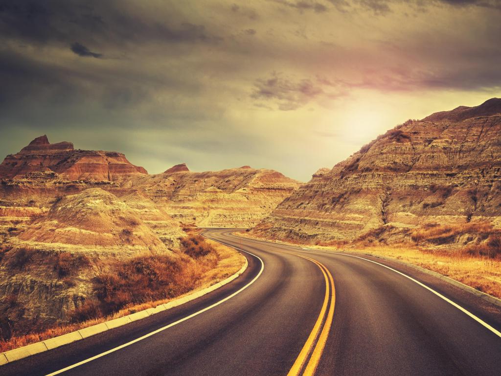 Scenic road at sunset, color toned picture, Badlands National Park, South Dakota, USA.